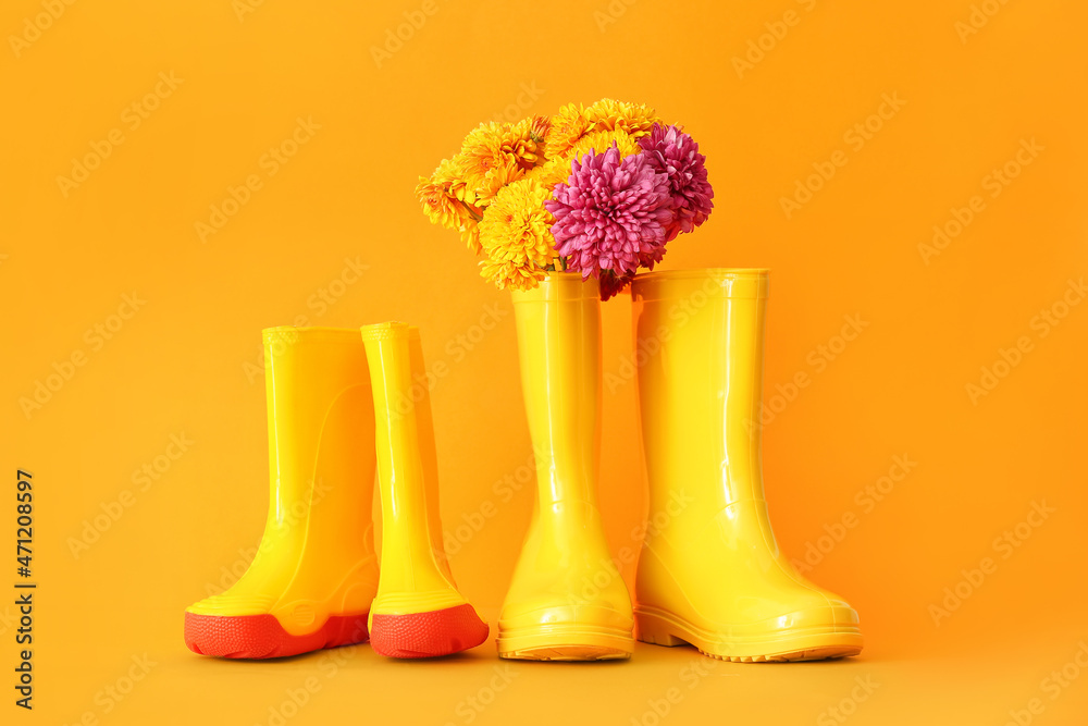 彩色背景上的橡胶靴和花朵