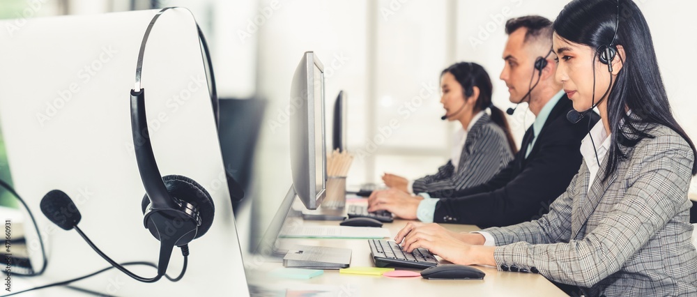 戴着耳机在办公室工作的商务人员为远程客户或同事提供支持。呼叫美分