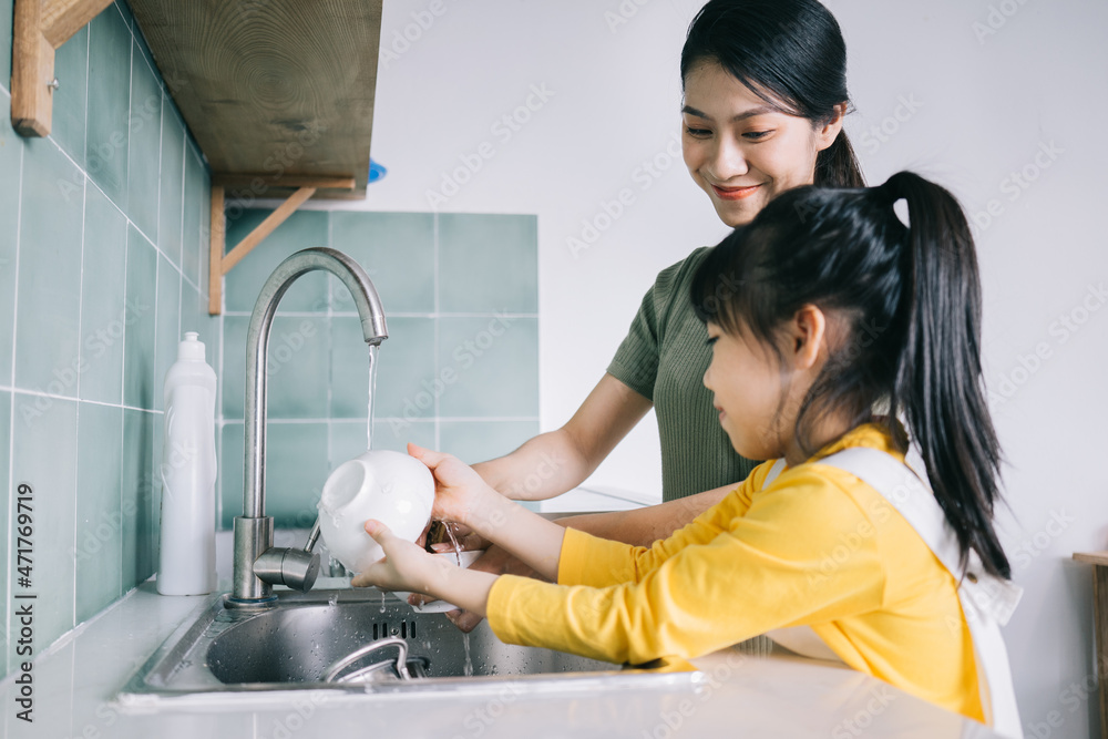 母亲和女儿一起洗碗。