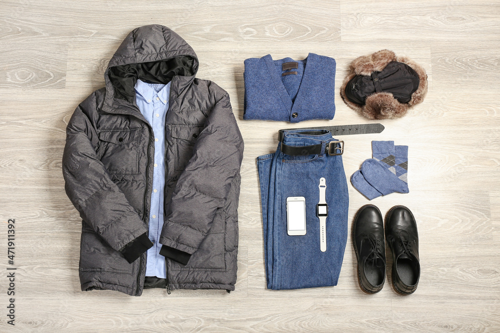 浅色木质背景下的时尚冬季夹克、男性服装和小工具