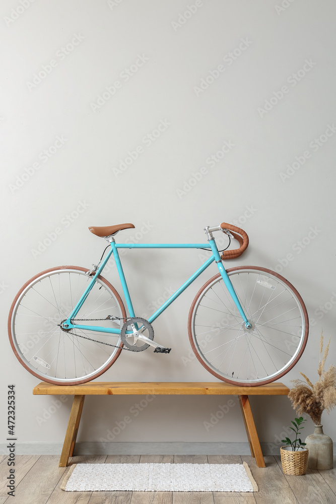轻型墙附近木长椅上的现代自行车