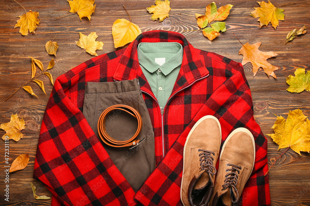 木质背景的时尚格子夹克、衬衫、裤子、腰带、鞋子和秋叶