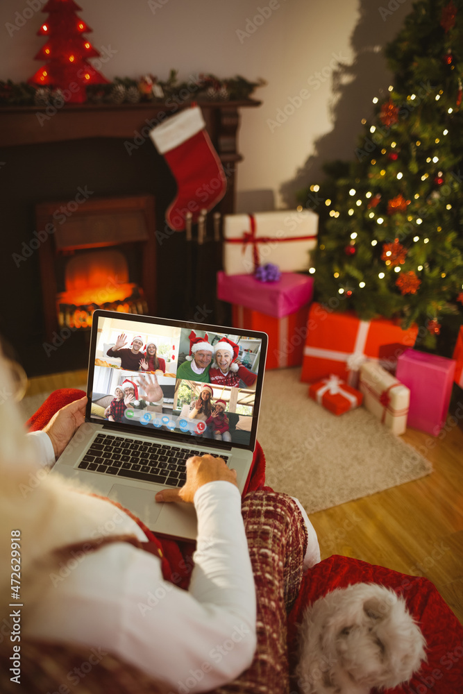 圣诞老人与微笑的高加索家人和朋友进行笔记本电脑圣诞集体视频通话