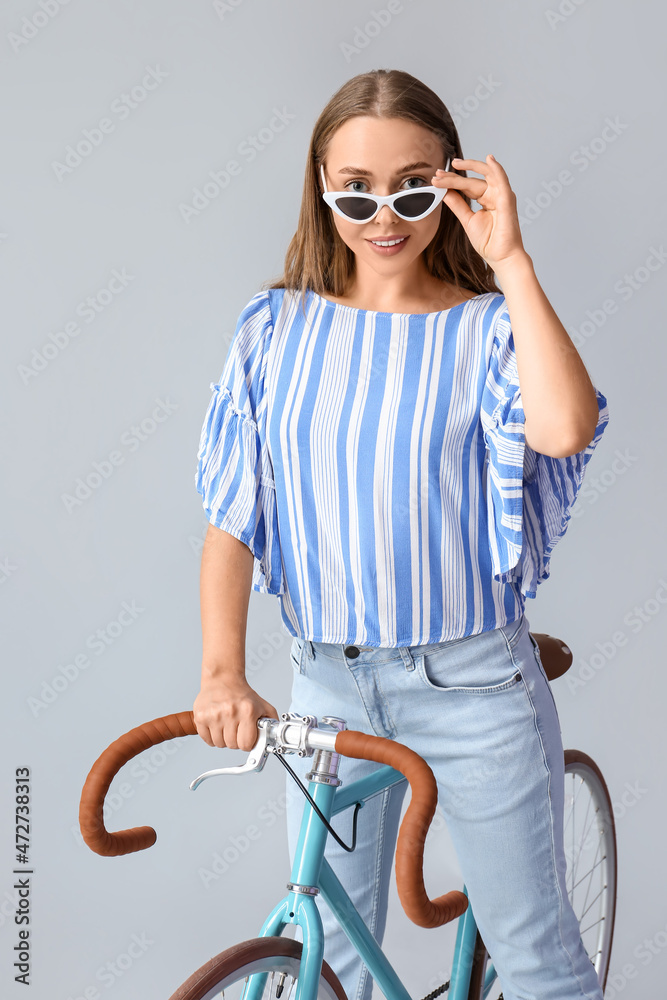 戴着墨镜的漂亮少女在灯光背景下骑自行车