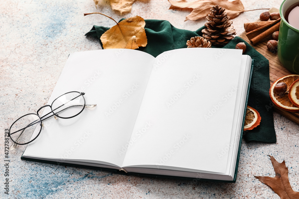 打开的书，空白页、眼镜和浅色背景的秋季装饰