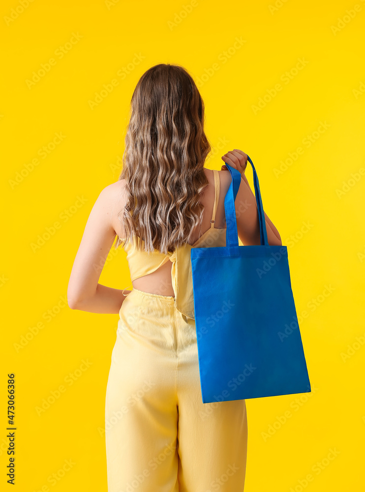 黄底蓝色环保袋的年轻女性