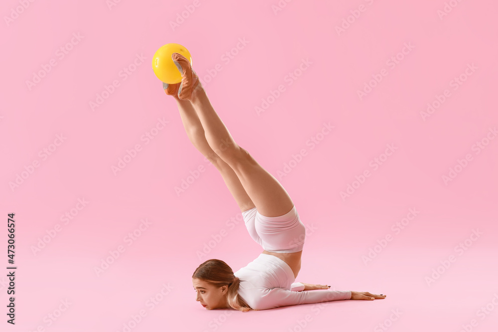 漂亮的年轻女子在彩色背景下用球做体操