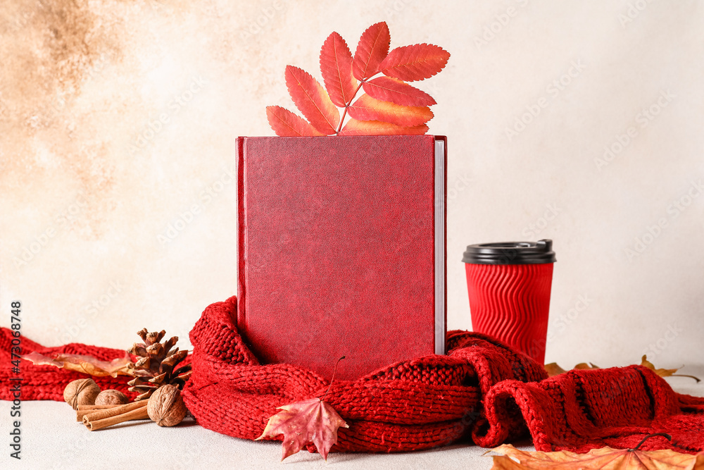 书籍、围巾、带饮料的纸杯和浅色背景的秋季装饰