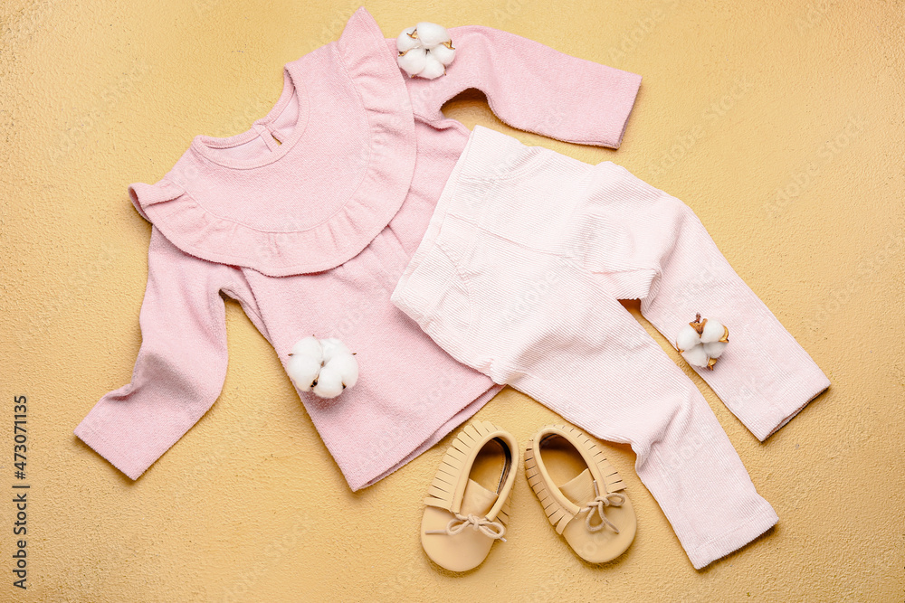时尚的婴儿衣服、鞋子和彩色背景的棉花花