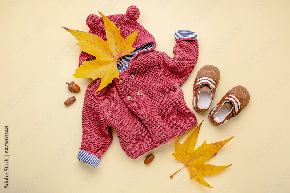 时尚的婴儿服装、鞋子和彩色背景的秋叶