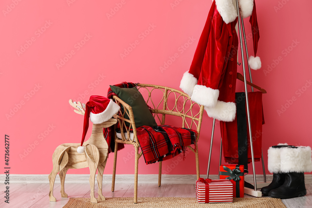 带格子和枕头的椅子，挂着圣诞老人服装和靴子的衣架，靠近彩色墙