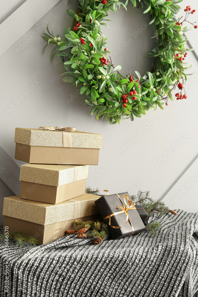 靠近灯光墙的桌子上有礼品盒、冷杉树枝和圣诞花环，特写