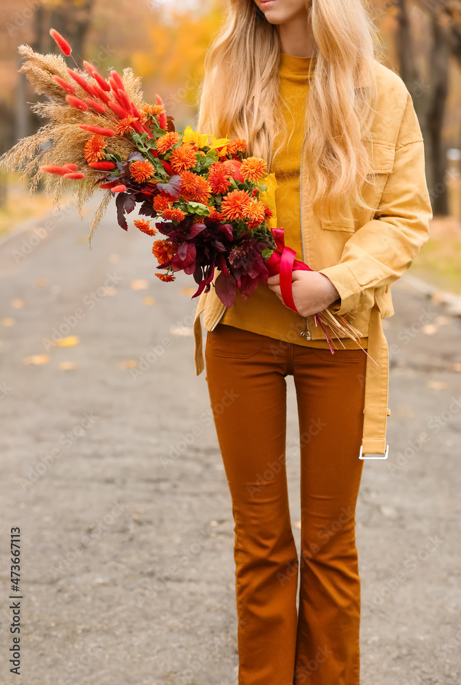 公园里有美丽的秋天花束的年轻女人，特写