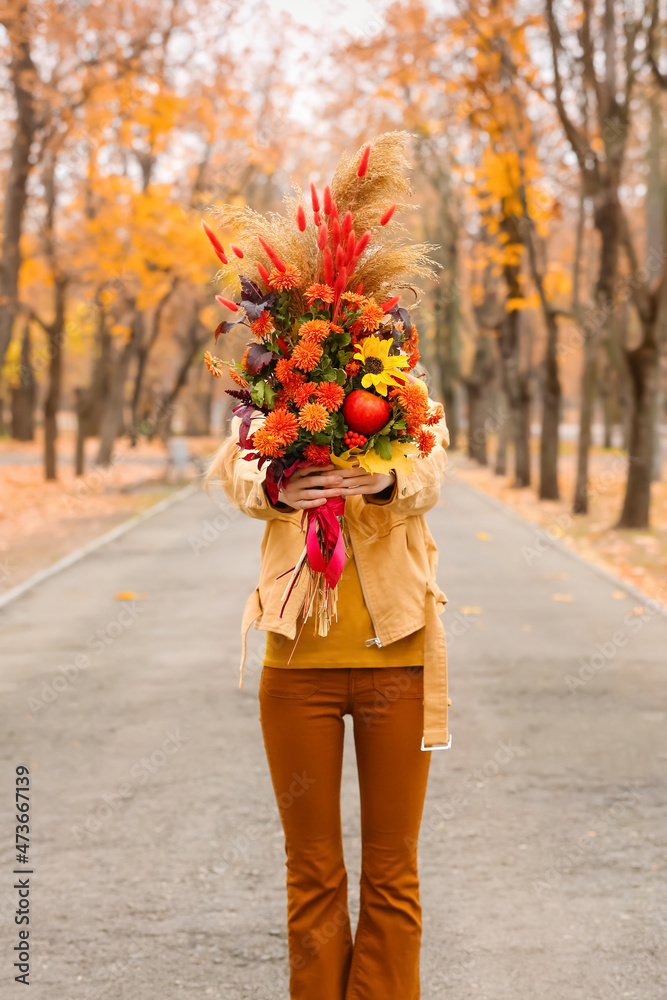 公园里拿着秋天美丽花束的女人