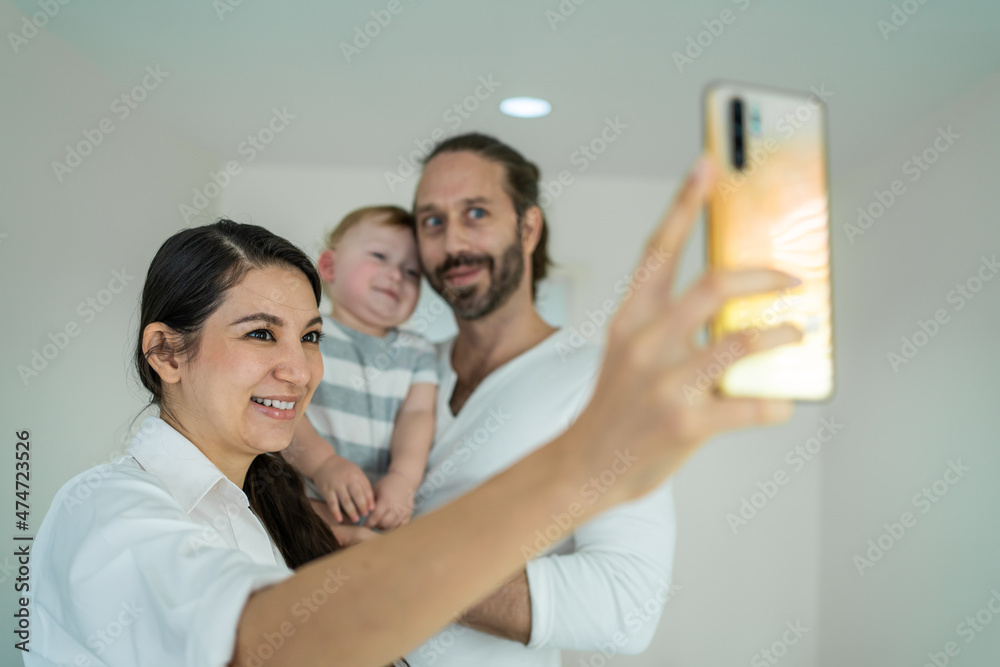 高加索幸福的家庭微笑，看着相机在手机上拍照。