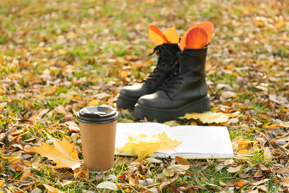 秋天公园里的时尚鞋子、纸杯咖啡、书籍和落叶
