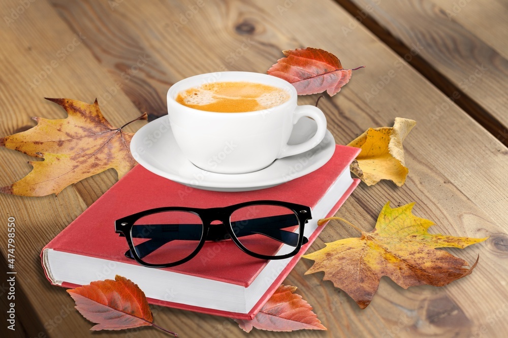 大气舒适的秋季构图。热杯子，书，落叶，