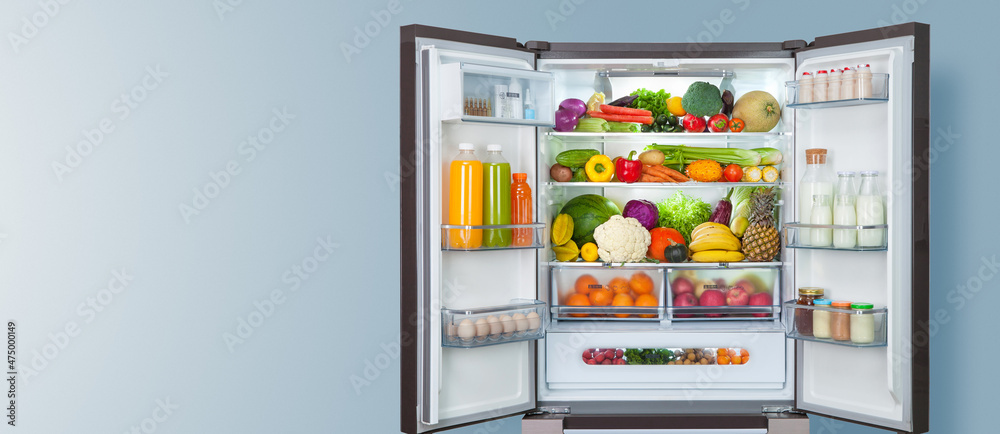 开放式冰箱中的不同水果和蔬菜。冷冻食品存储背景。