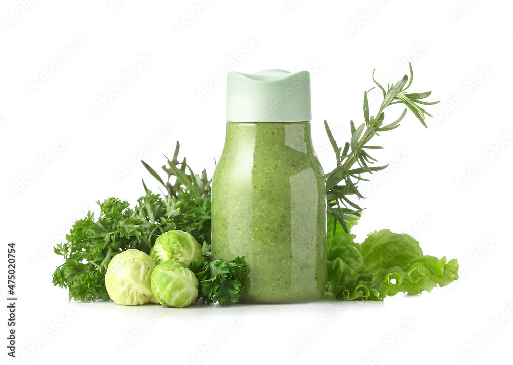 一瓶健康的绿色奶昔和白底蔬菜