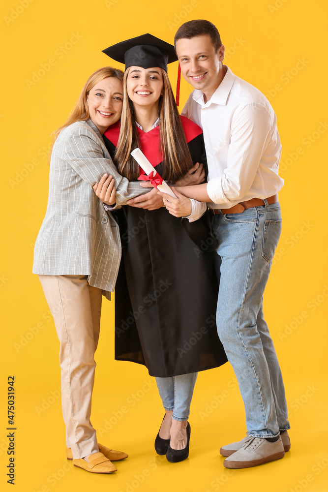快乐的女毕业学生和她的父母在彩色背景下