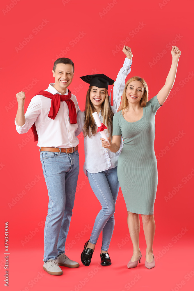 快乐的女毕业学生，和她的父母在彩色背景上
