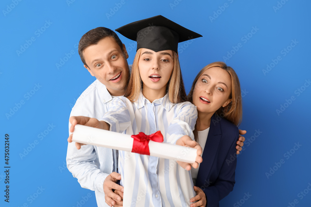 惊讶的女毕业学生和她的父母在彩色背景上