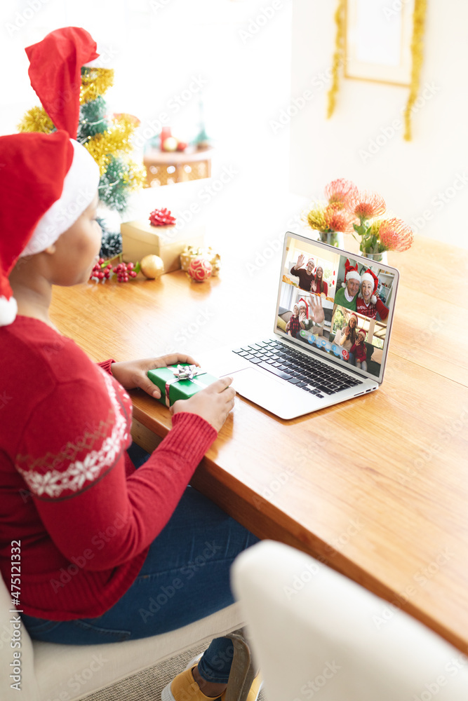 戴着圣诞帽的非裔美国妇女与不同的朋友进行笔记本电脑圣诞小组视频通话