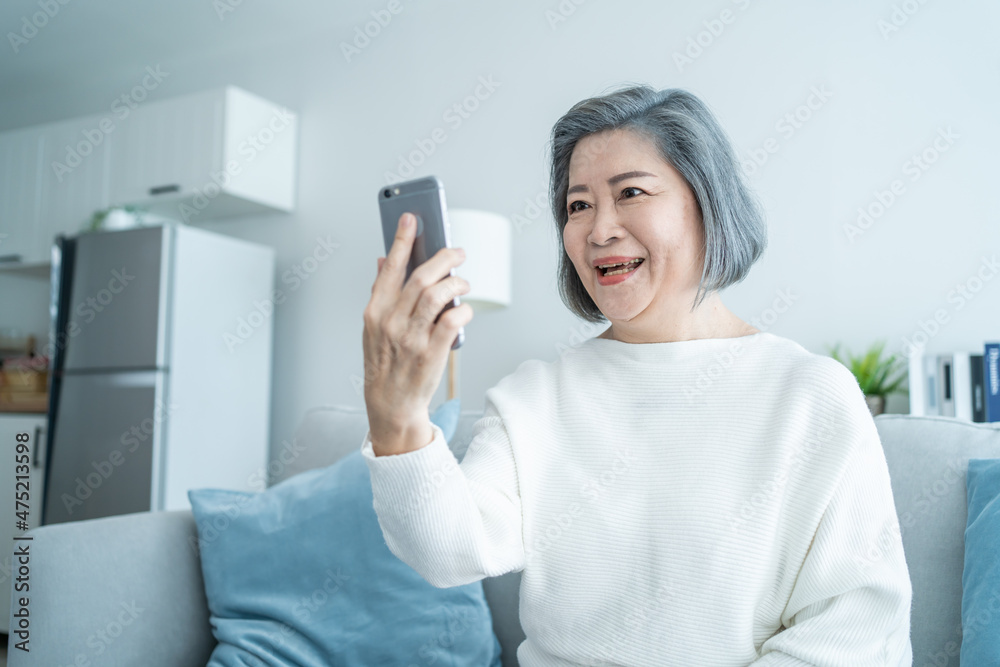 亚洲老年妇女在家客厅微笑视频通话
