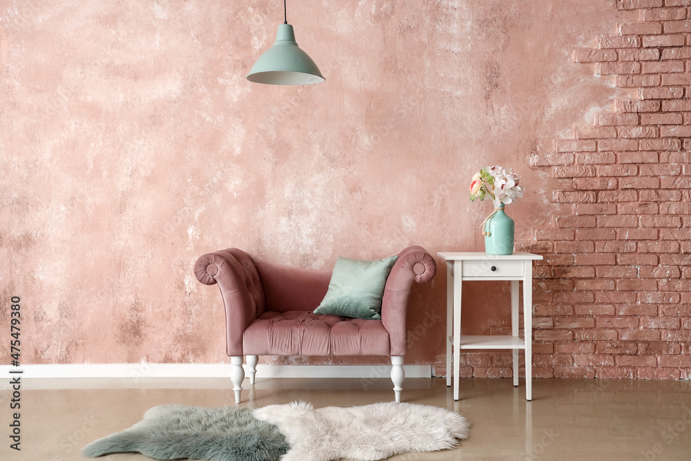 时尚的扶手椅和花瓶，靠近粉色墙壁的桌子上有花