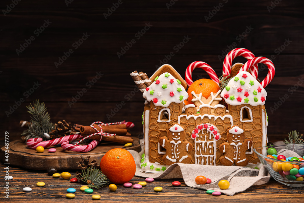 木制背景上的姜饼屋、橘子和甜点