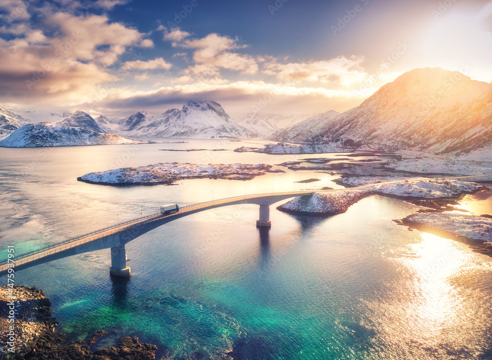 挪威罗弗敦群岛的桥梁、大海和雪山鸟瞰图。日落时的Fredvang大桥