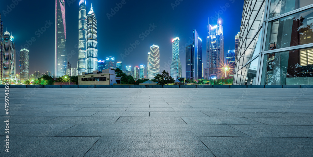 Panoramic skyline and modern commercial office buildings with empty square in Shanghai at night