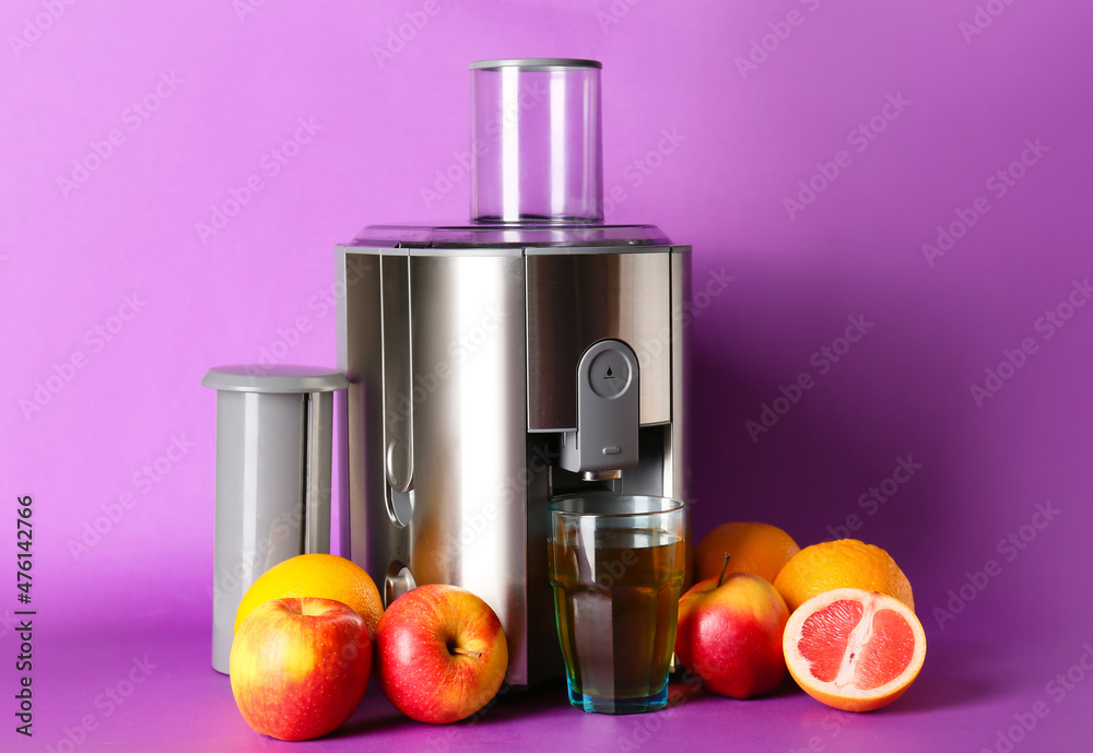 Modern juicer with fresh fruits on purple background