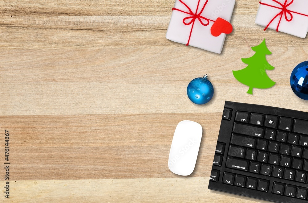 圣诞和新年办公空间，配有键盘电脑、无线鼠标、小饰品和礼品盒。