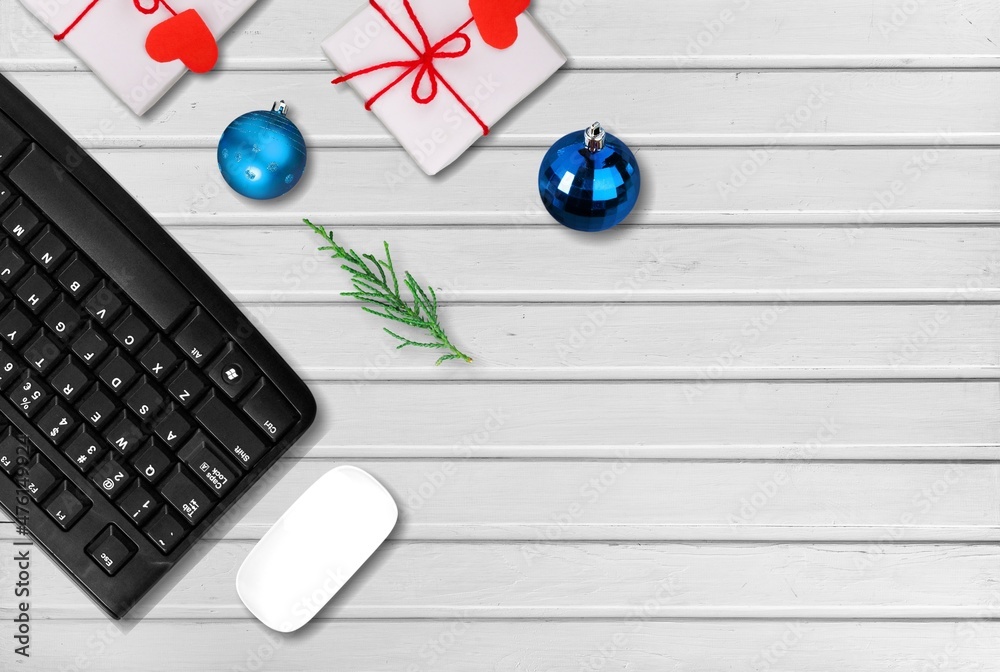 圣诞和新年办公空间，配有键盘电脑、无线鼠标、小玩意和礼品盒。