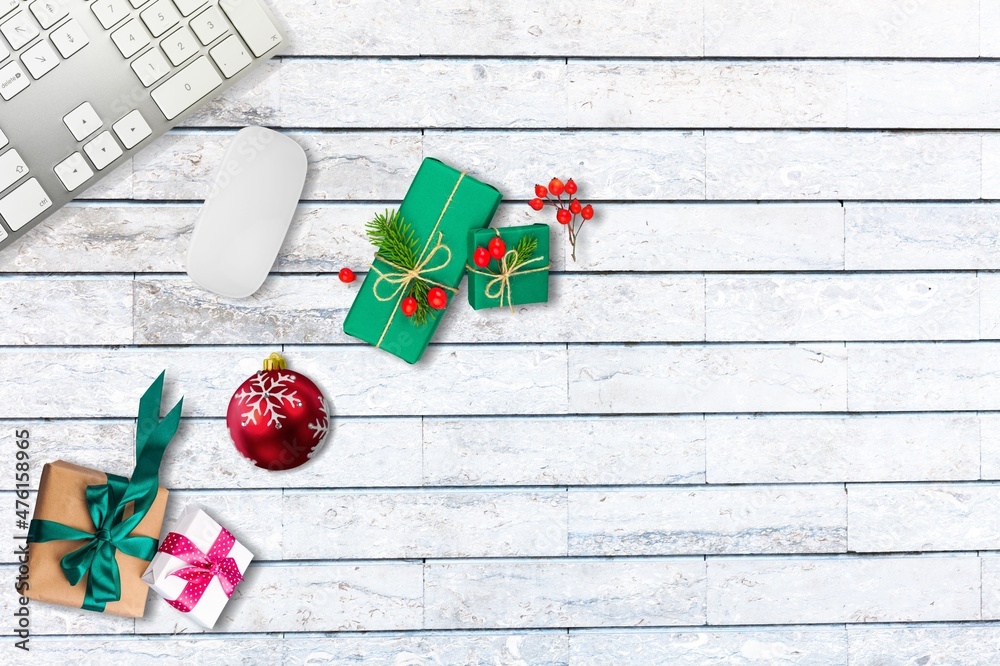 圣诞和新年办公空间，配有键盘电脑、无线鼠标、小玩意和礼品盒。