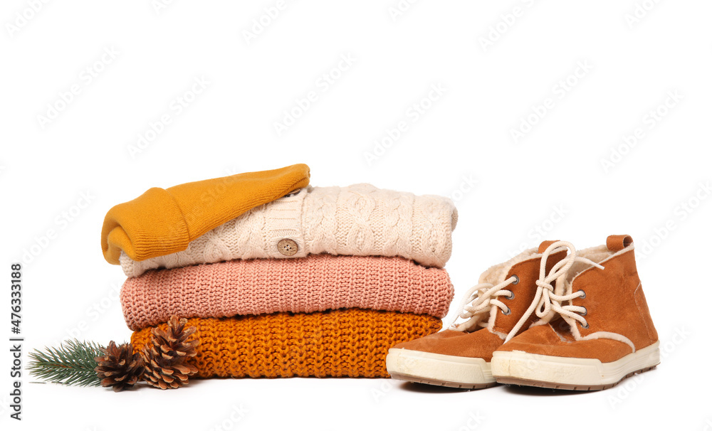 白色背景上的一堆针织毛衣、鞋子、帽子和冬季装饰