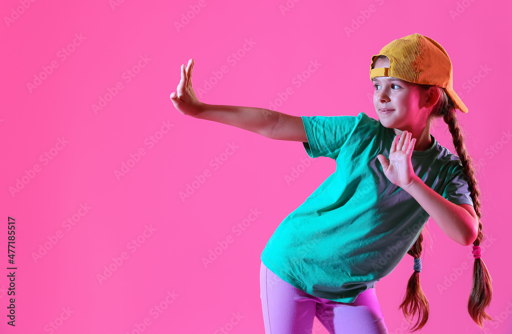戴帽子的可爱小女孩在粉色背景下跳舞