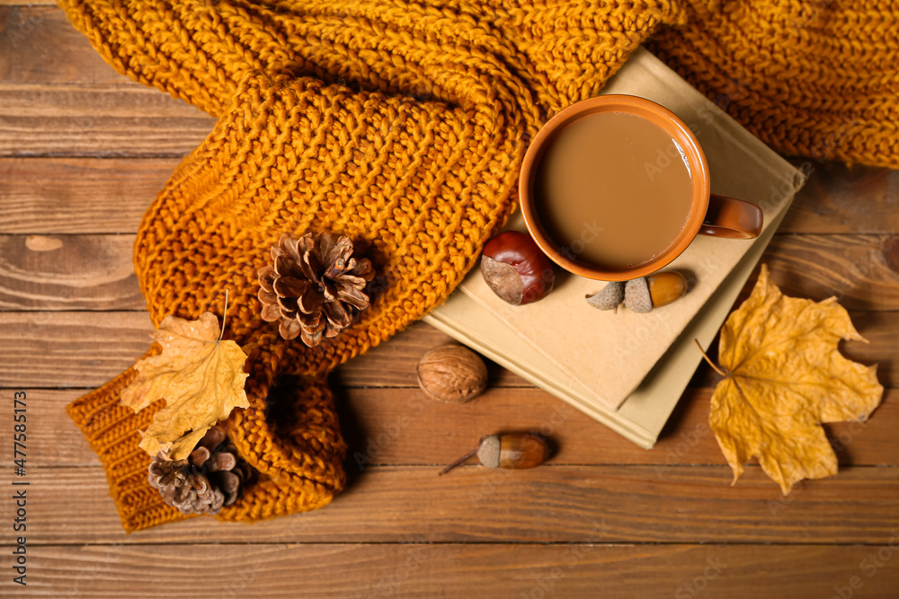 一杯美味的咖啡、书籍和木制背景的秋季装饰