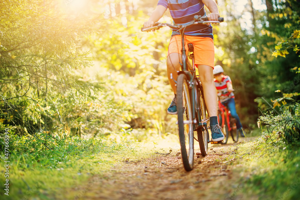 清晨，孩子们在森林里骑自行车。男孩们在大自然中户外骑行