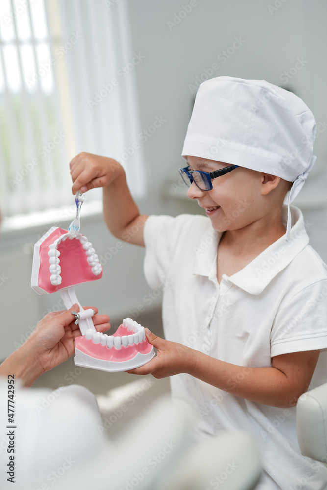 口腔保健小牙医男孩穿着医疗服。口腔儿童牙科制服。