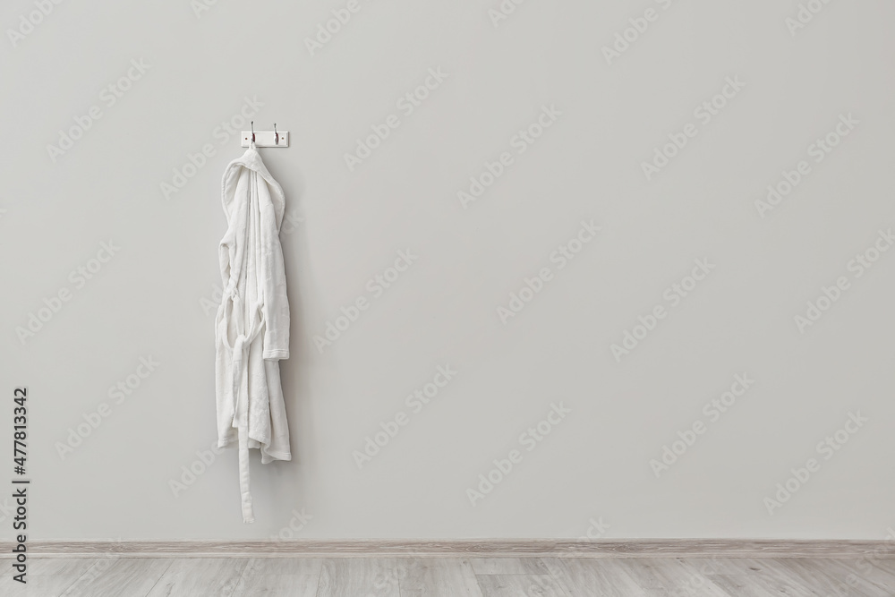白色浴袍挂在浅色墙上