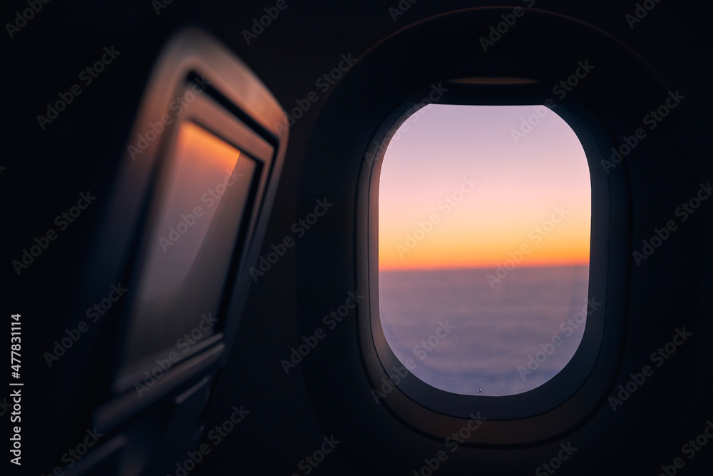 美丽日落时，飞机在云层上方飞行时的窗口。