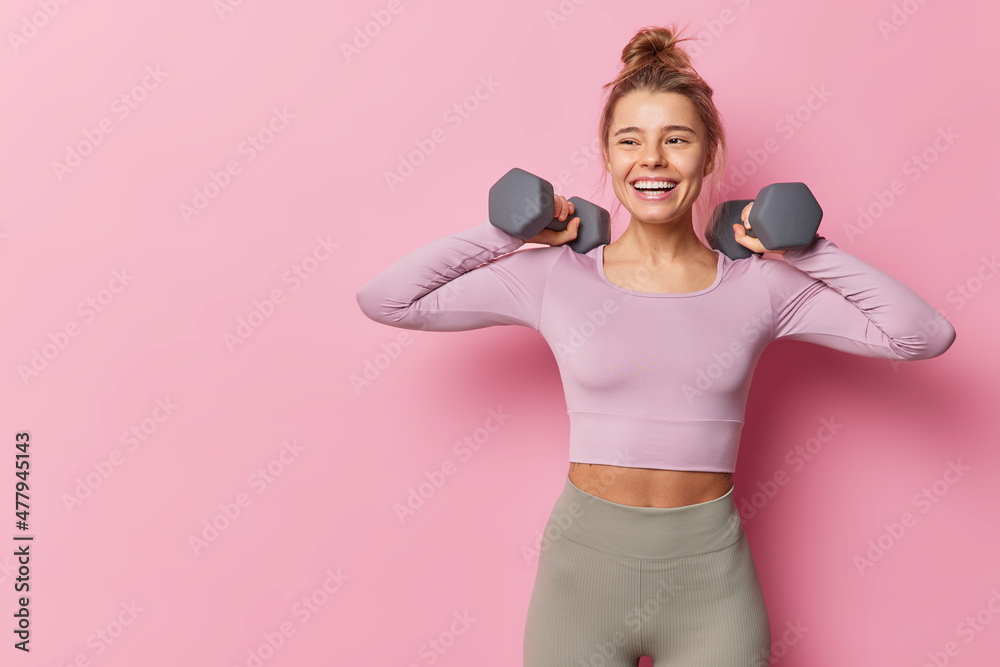 运动服女运动员举起哑铃，在健身房锻炼肱二头肌充满活力，健康