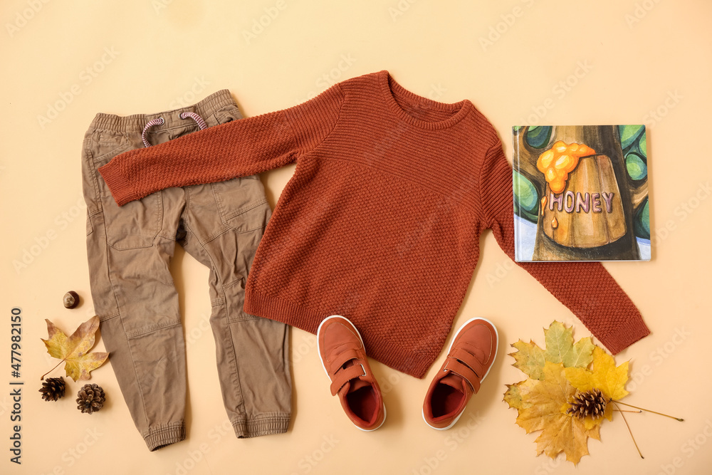 一套时尚的儿童服装、书籍和秋季装饰，颜色背景