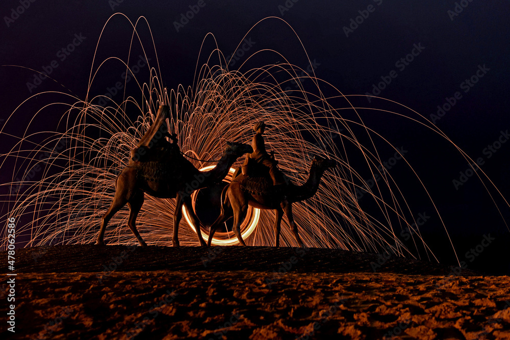 ラクダの銅像と火花の光跡