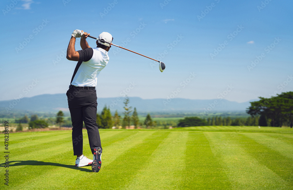 亚洲男子在球场上打高尔夫。在夏天