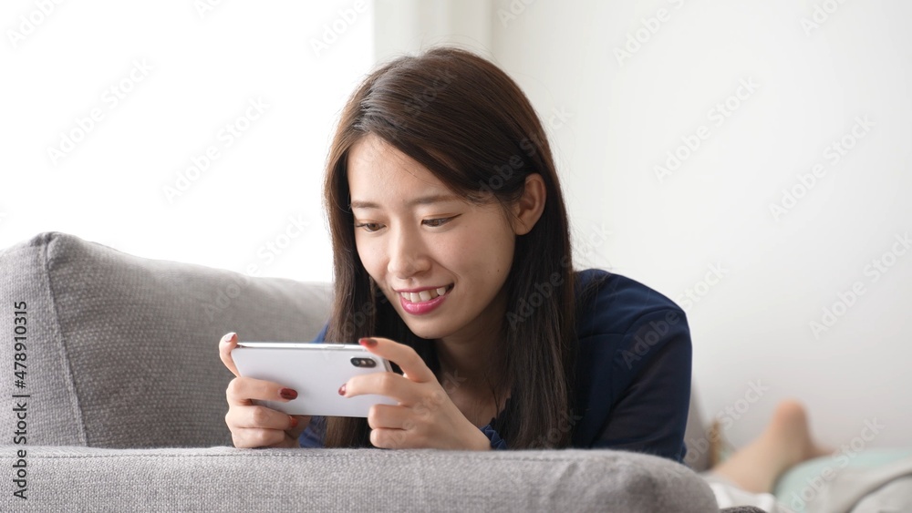 スマートフォンでゲームをプレイする女性