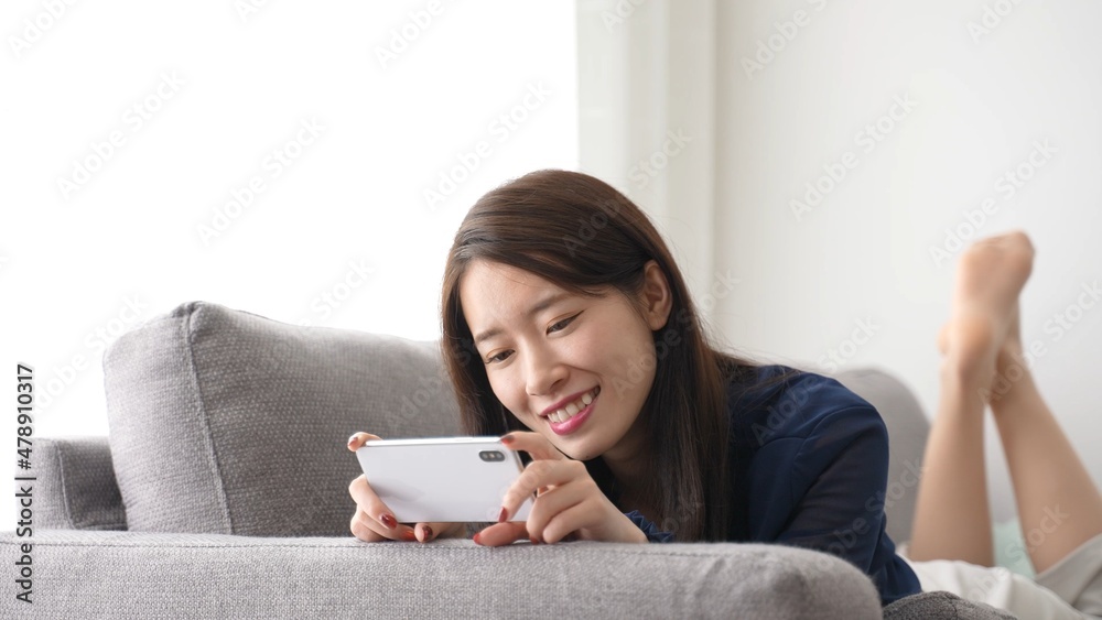 スマートフォンで動画を鑑賞する女性