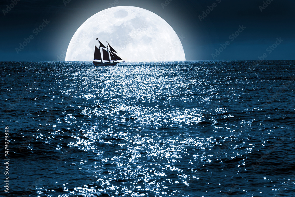 当一艘帆船静静地在它前面航行时，巨大的蓝色满月升起在这片海洋上。